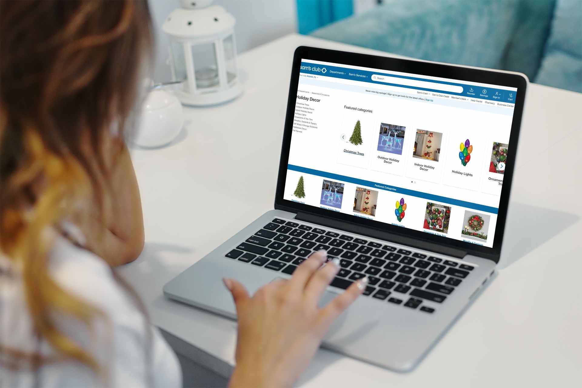 Woman on a laptop browsing the sam's club website for Christmas decor