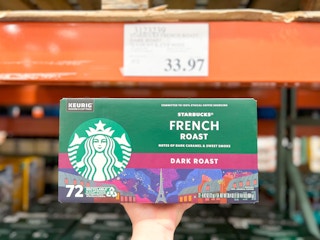 a person holding starbucks coffee in costco