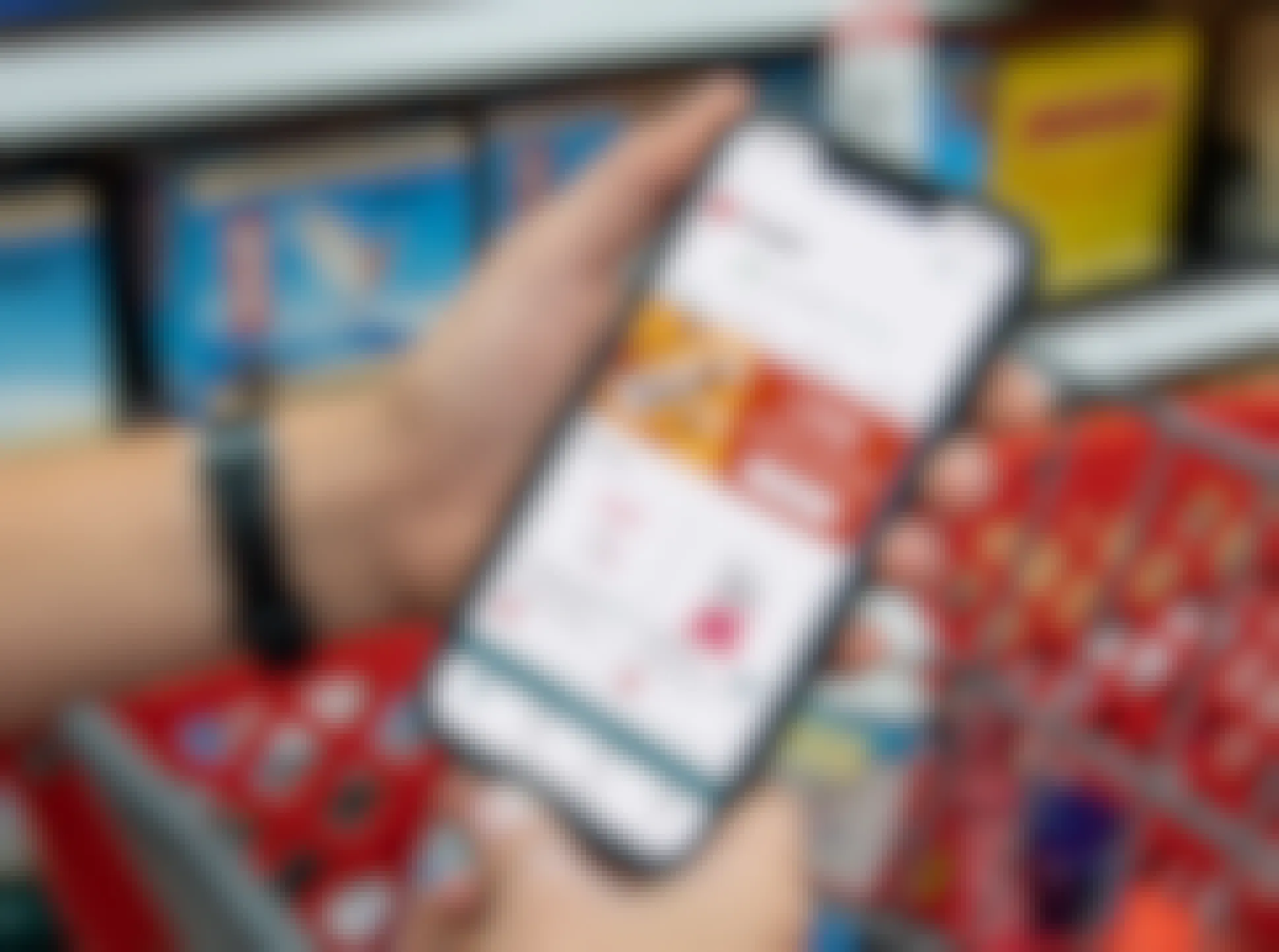 a woman's hands holding a cell phone looking at Ibotta deals for Target in the Ibotta app