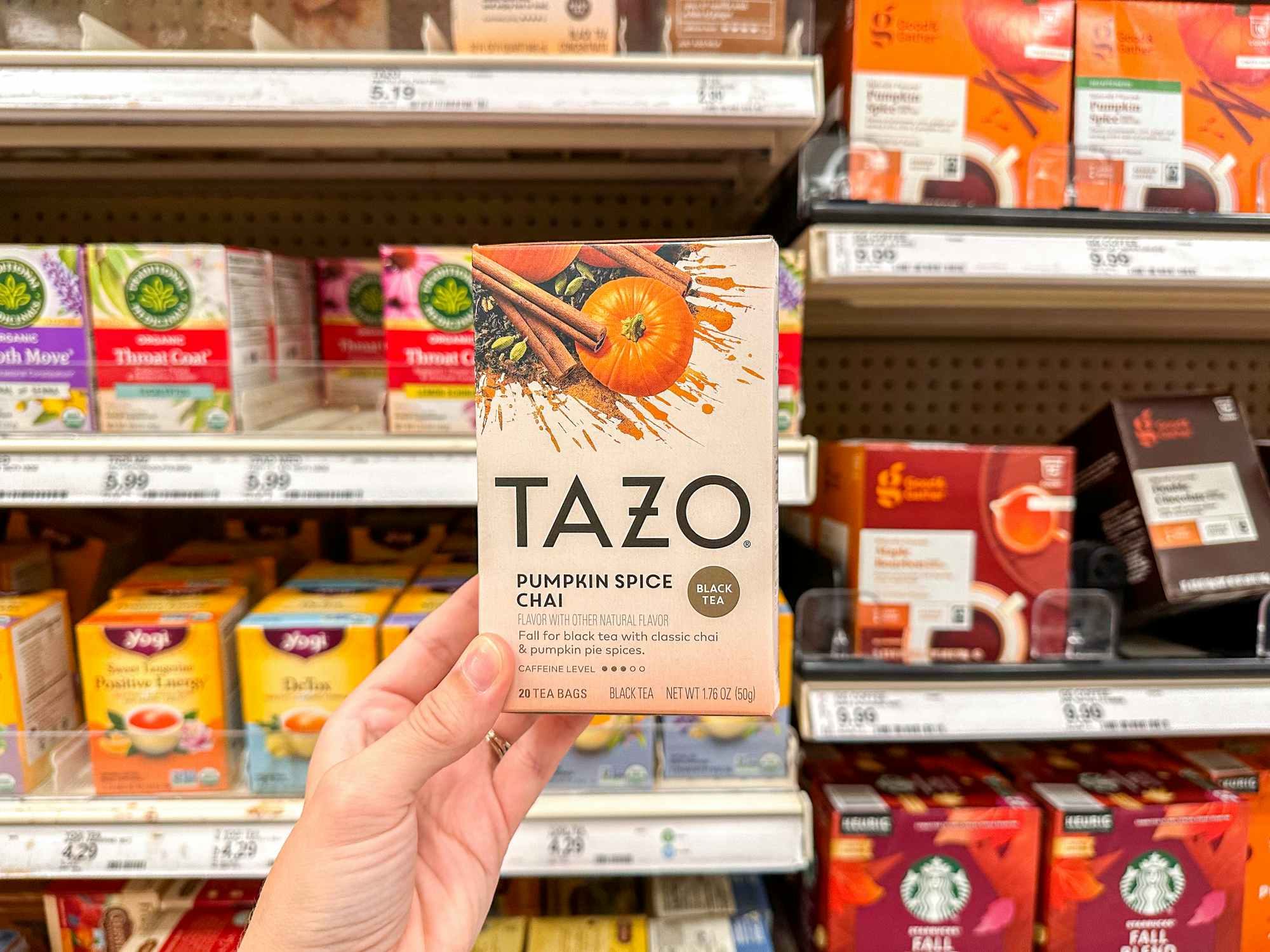 a person holding up pumpkin tazo spiced chai at target