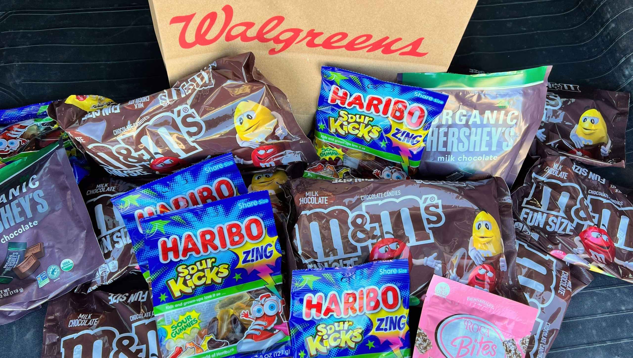 m&m, haribo, hershey candy by a walgreens bag