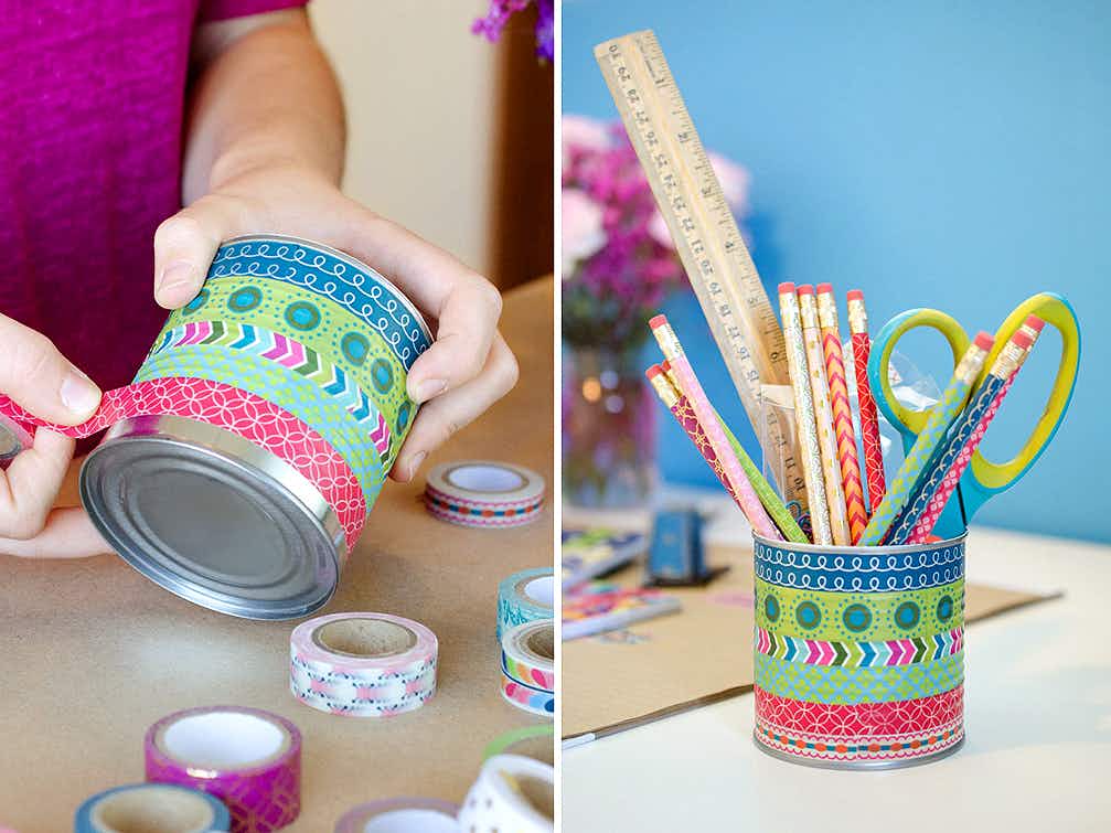 A person putting washi tape on a tin can and a finished, washi tape-decorated can sitting on a desk, filled with pencils, scissors and a ruler.