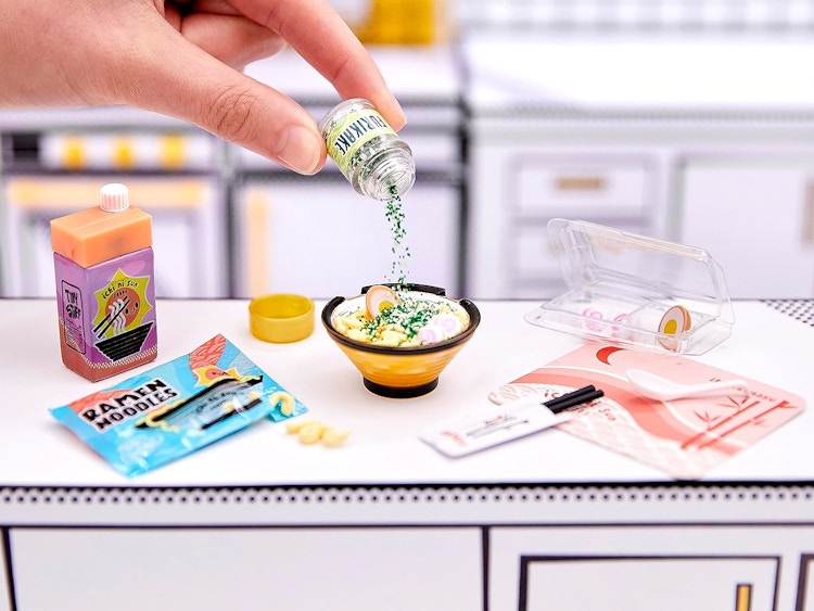 someone playing with a mini replica food set