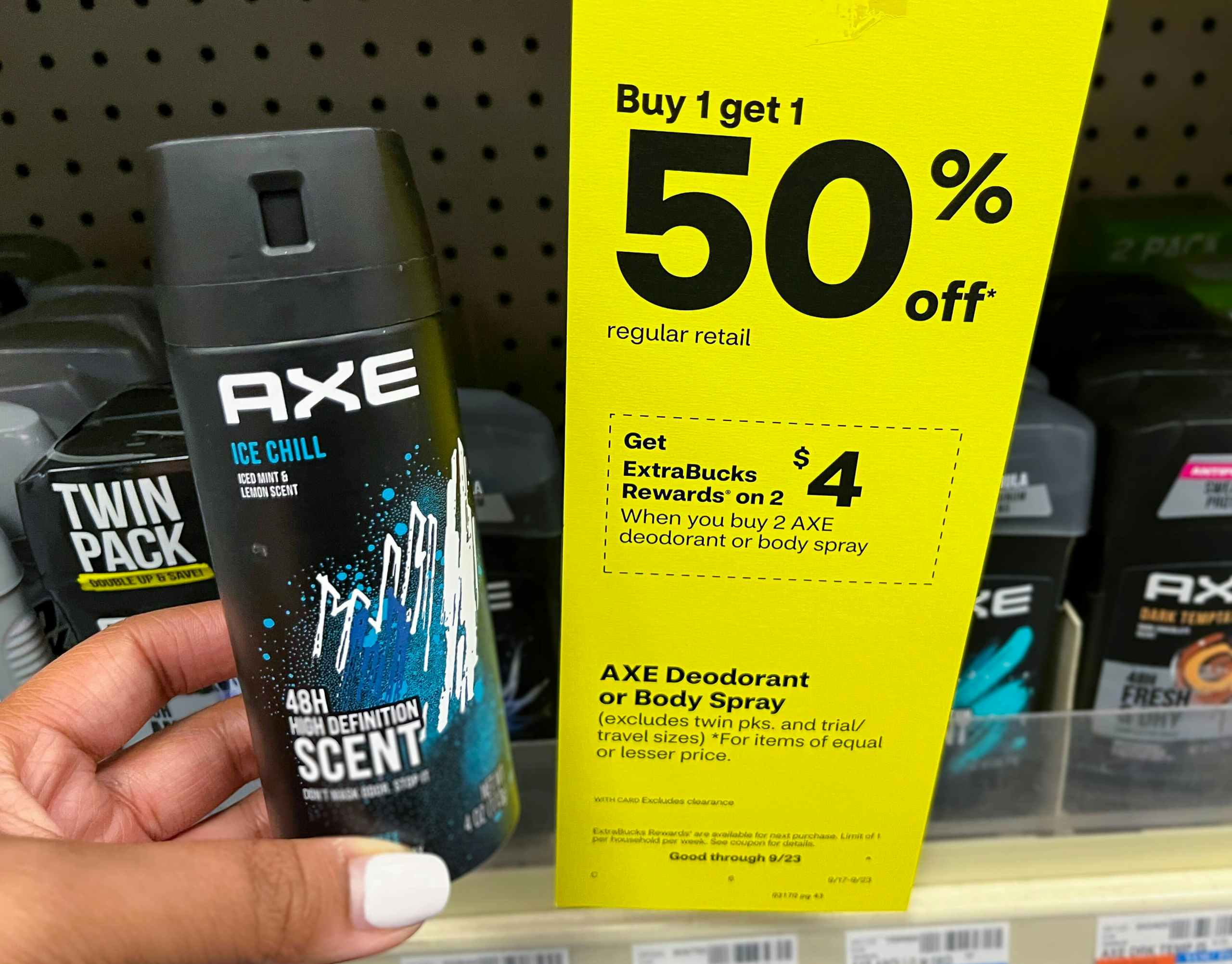 person holding Axe deodorant spray next to sales tag