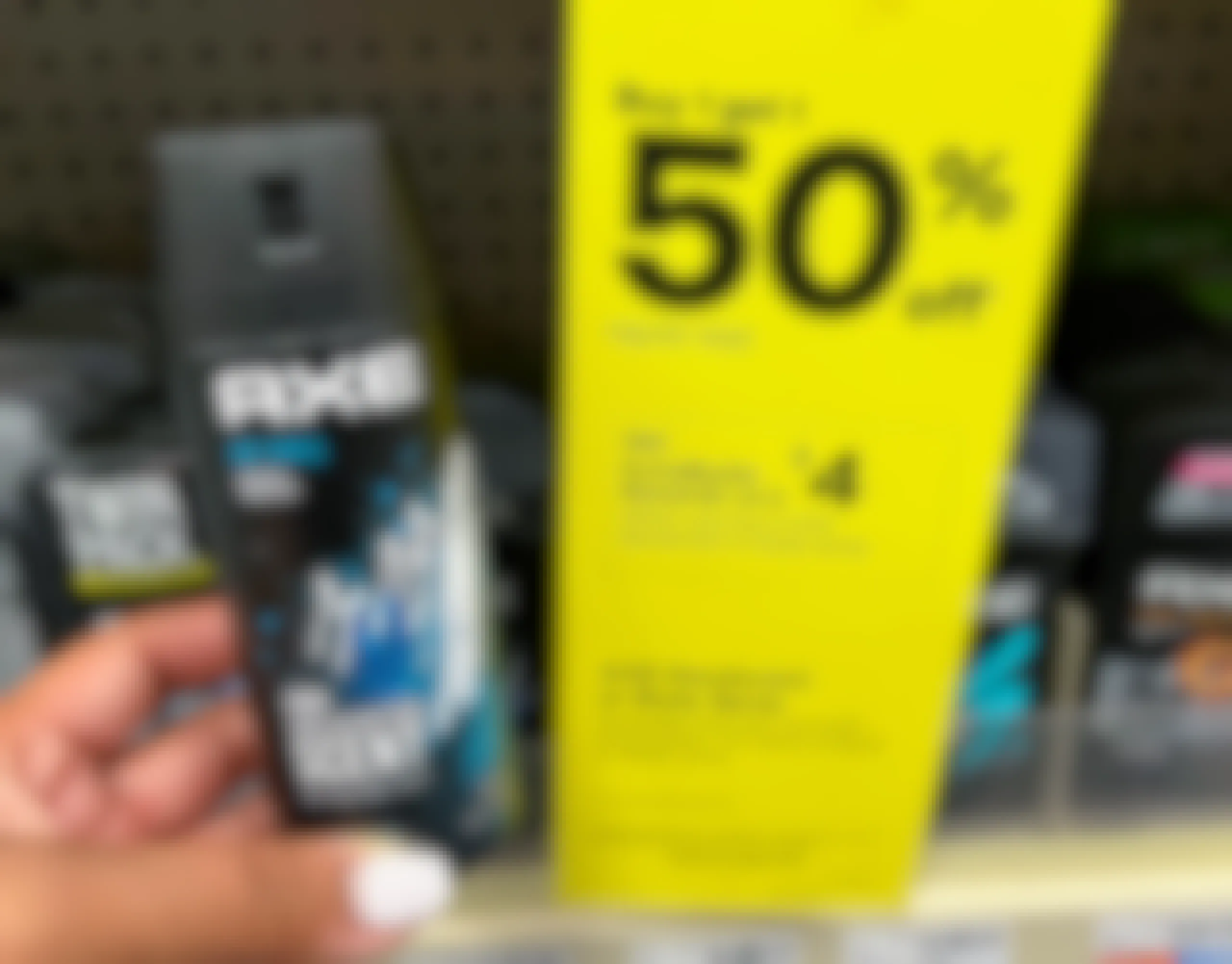 person holding Axe deodorant spray next to sales tag