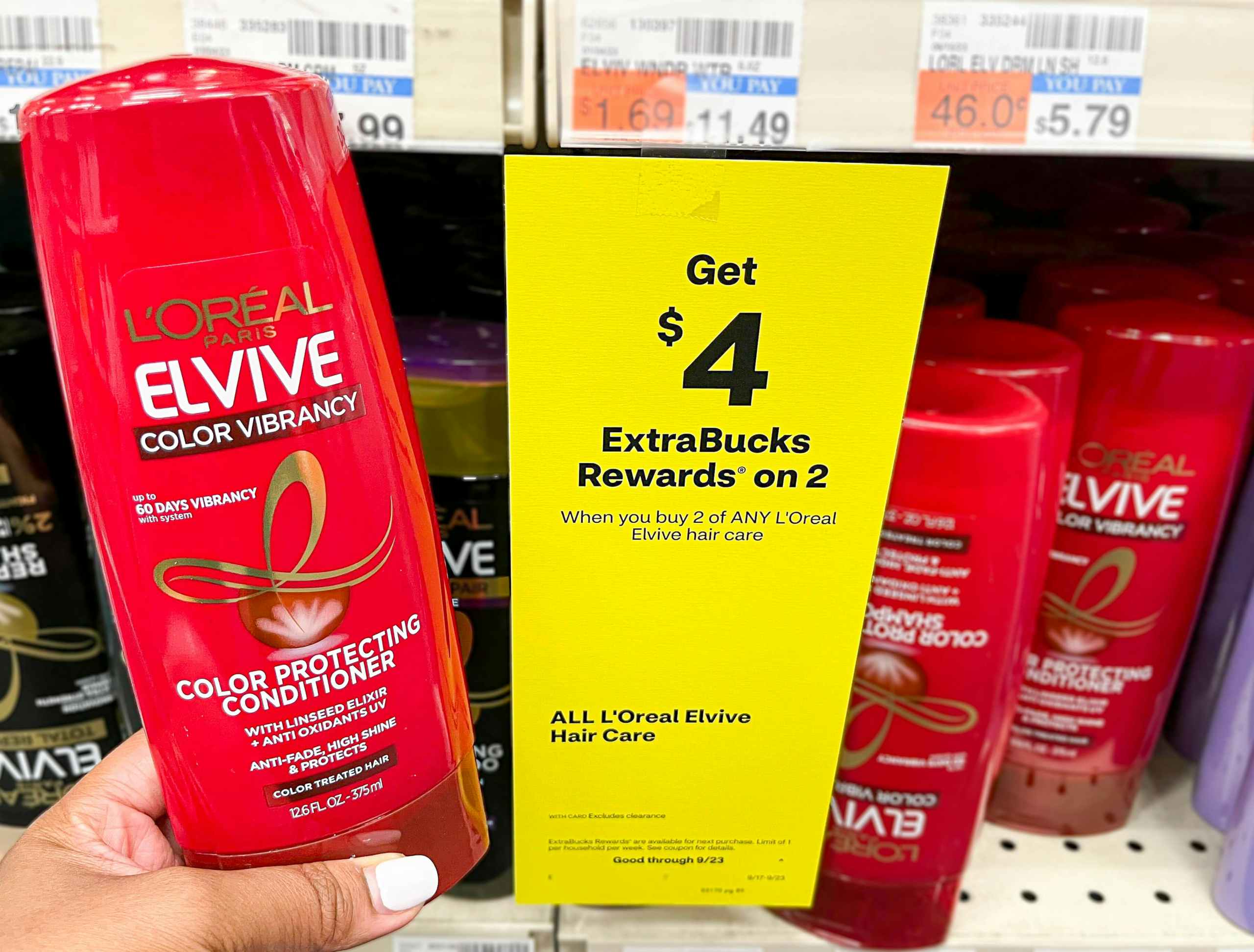 person holding a bottle of L'Oreal Elvive next to sales tag