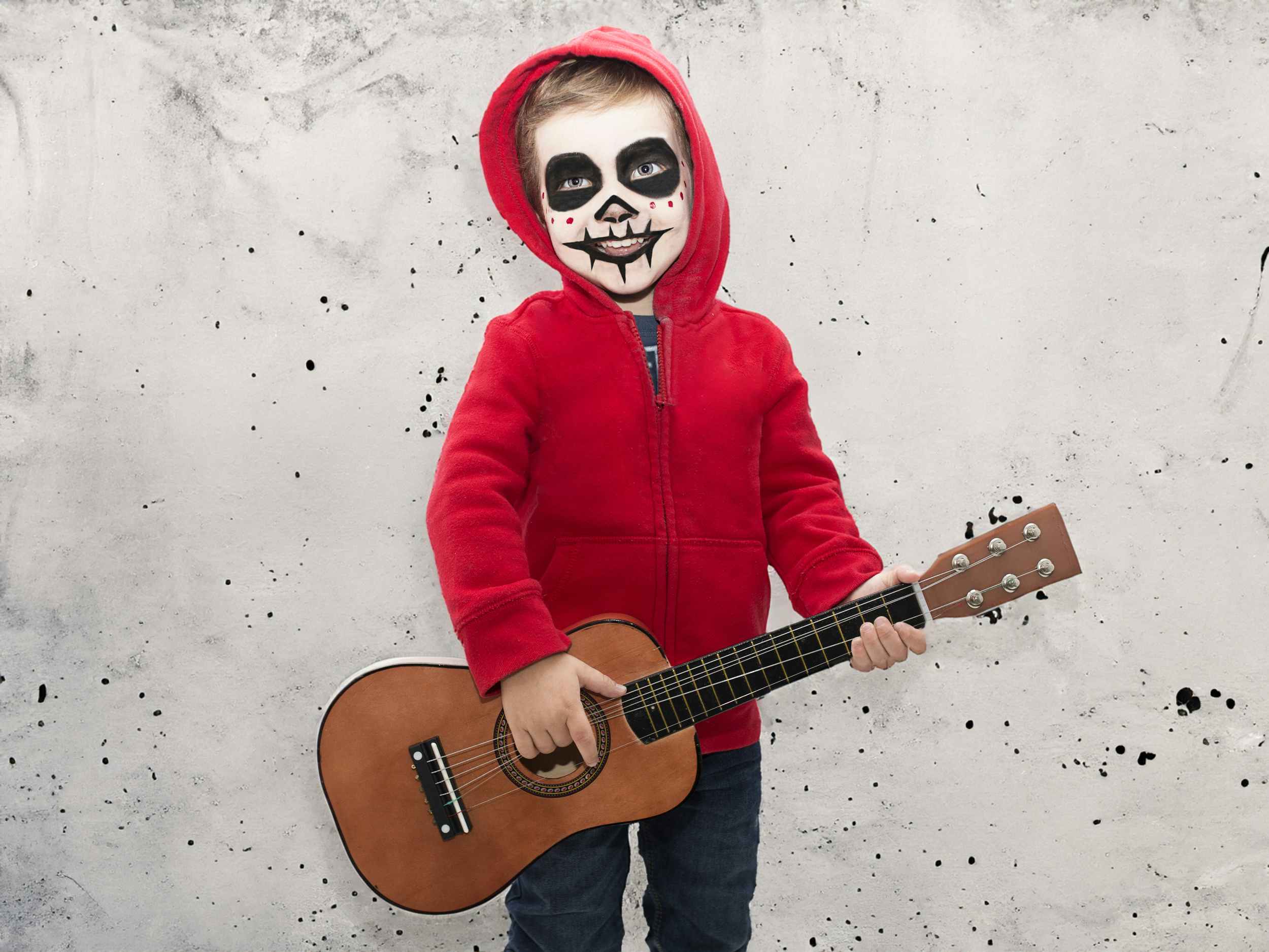 child dressed up for halloween like miguel from the movie coco