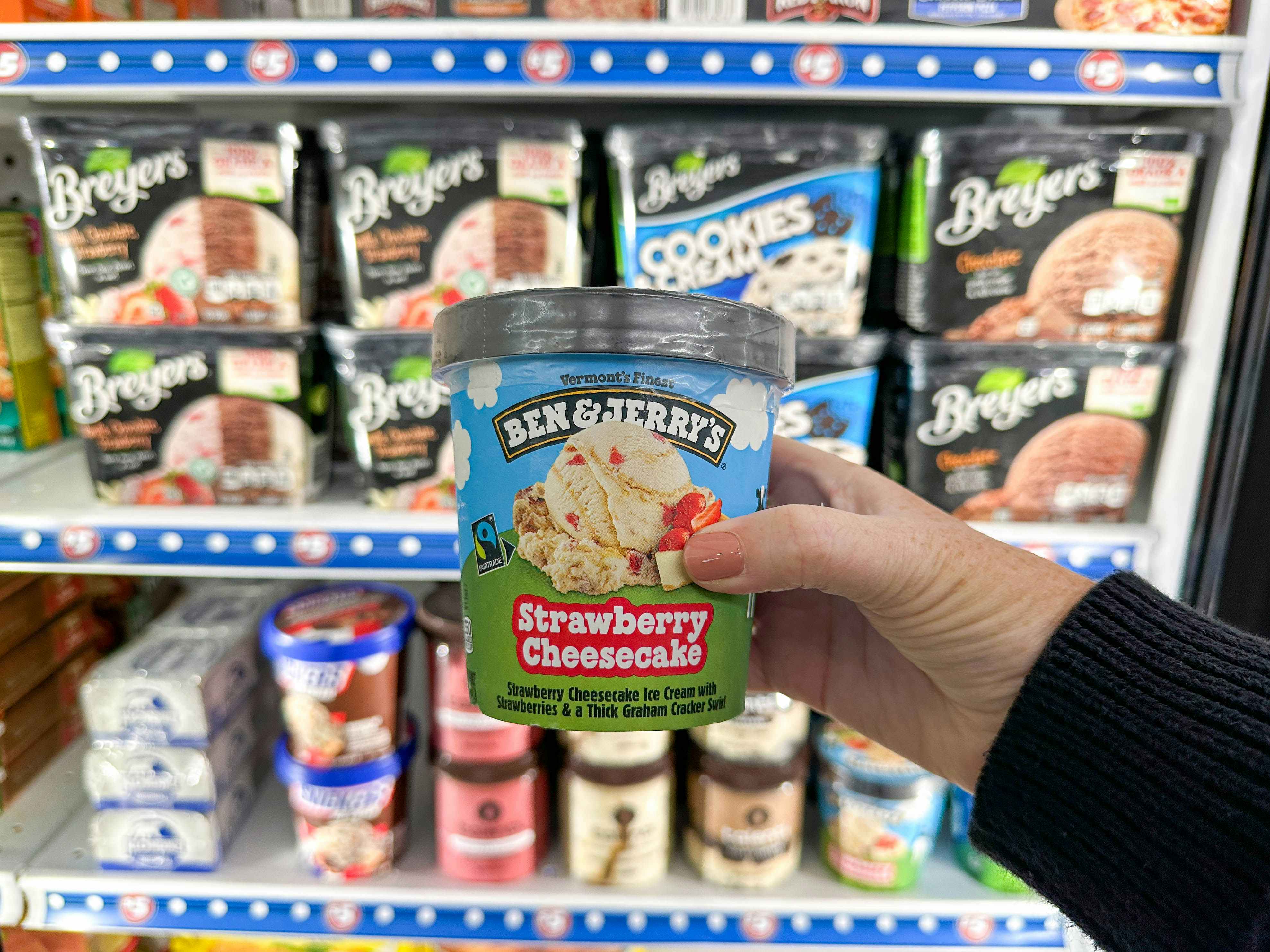 a person holding ben and jerry ice cream
