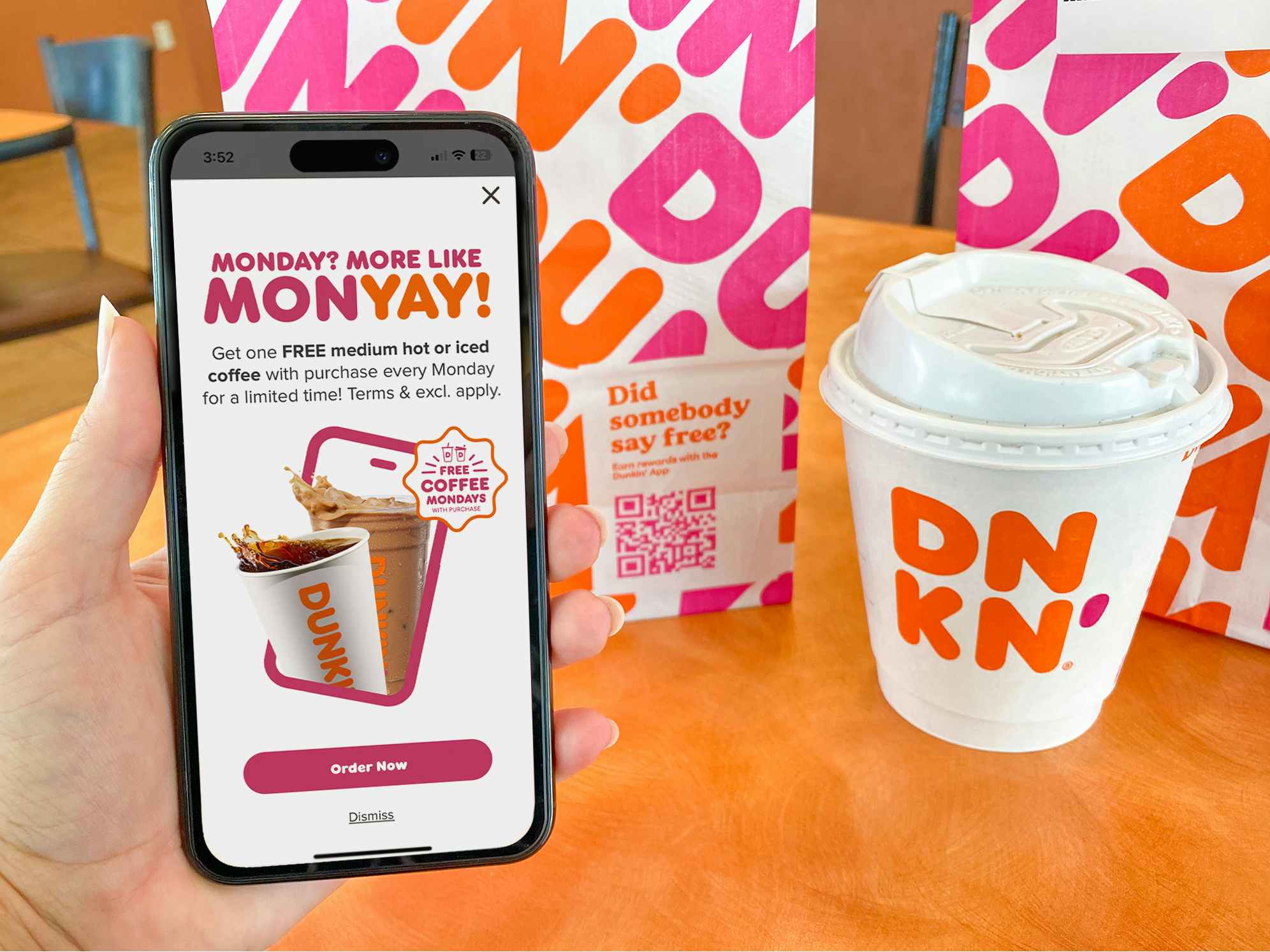 someone holding a phone displaying the pop-up for the Dunkin September Member Exclusive offer for free coffee on Mondays