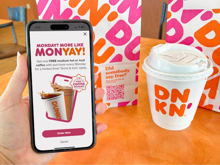 someone holding a phone displaying the pop-up for the Dunkin September Member Exclusive offer for free coffee on Mondays