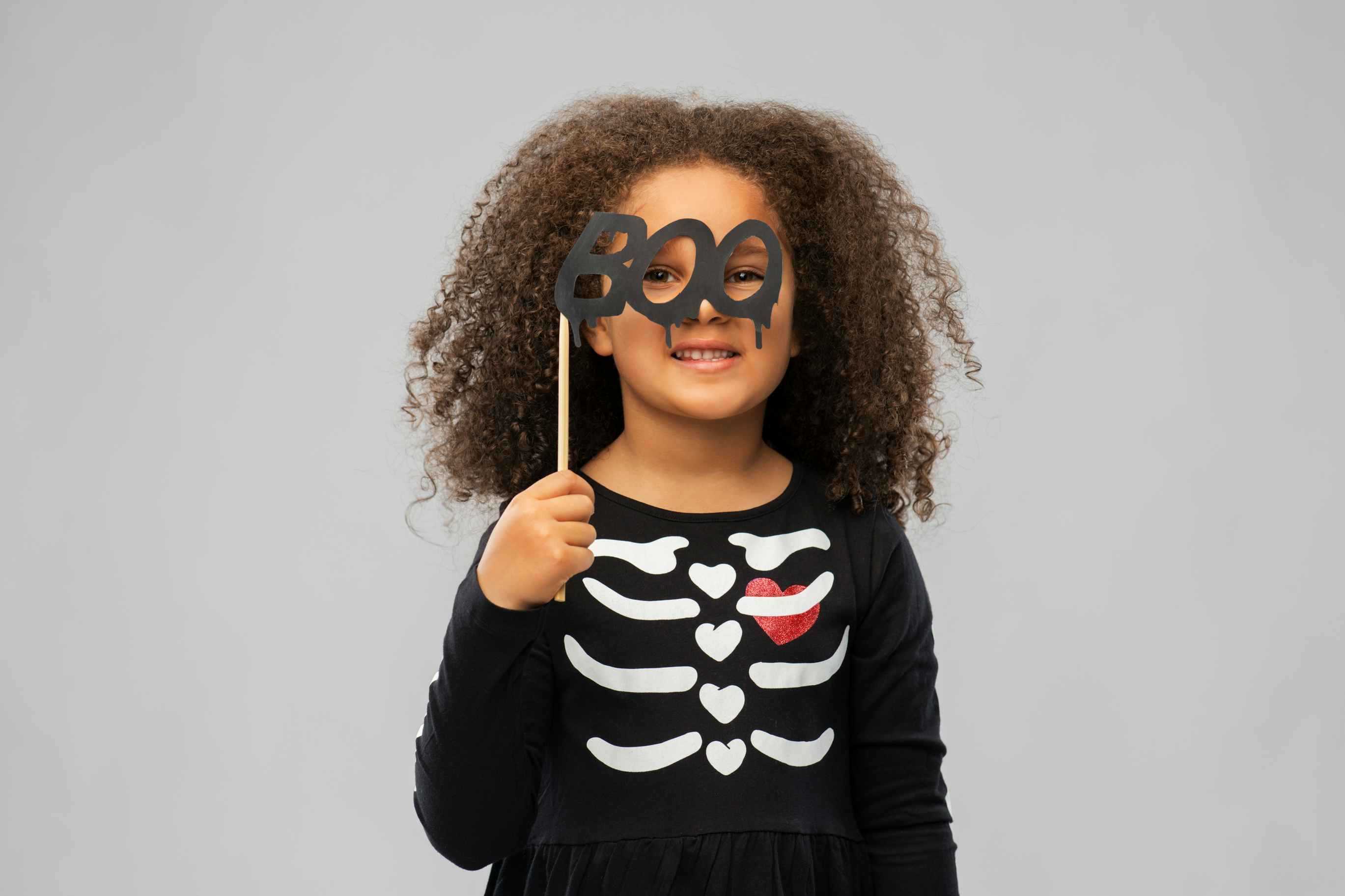 child smiling with halloween mask