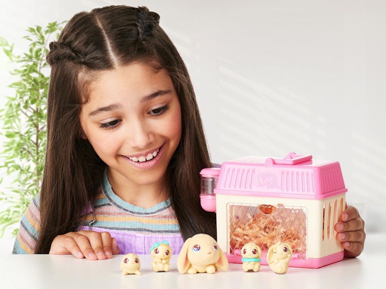 a little girl playing with a Little Live Pets Mama Surprise Mini set