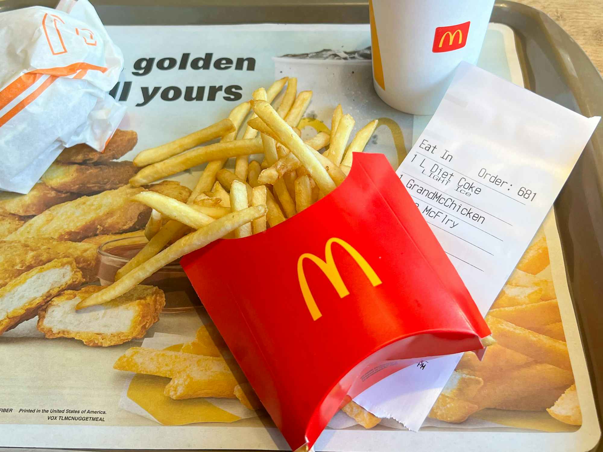 some McDonald's fries on a tray with a receipt
