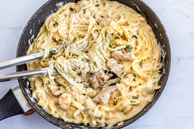 zchicken pasta in a skillet with togns