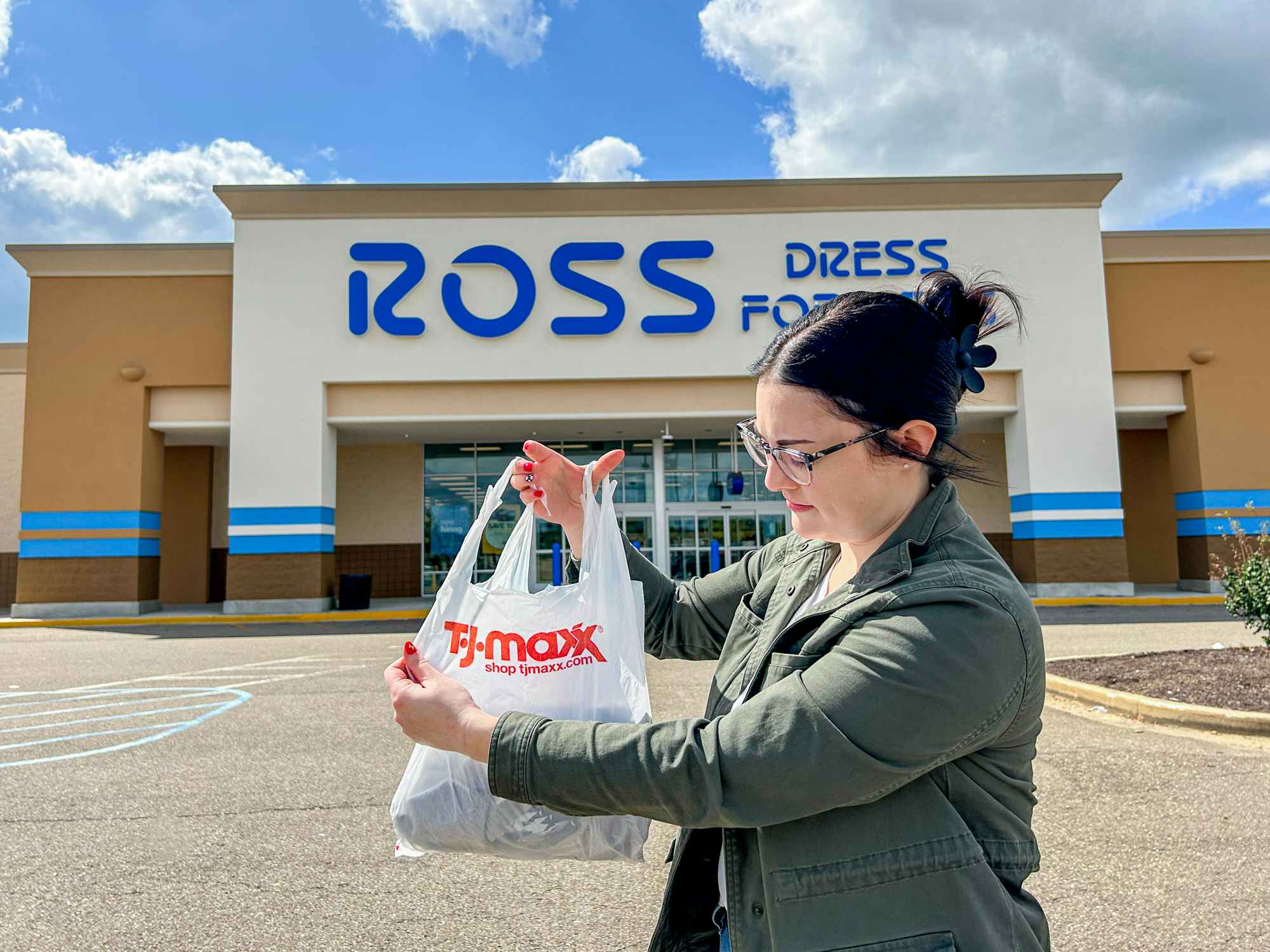 a person holding up a tj maxx bag in front of a ross sign