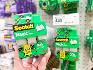 Hand holding scotch tape near price tag