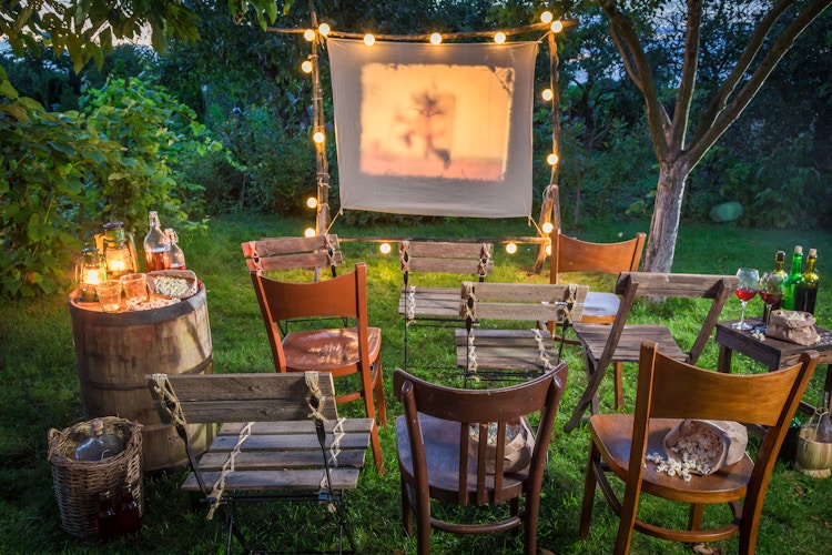 Chairs out for a movie being projected on a white sheet