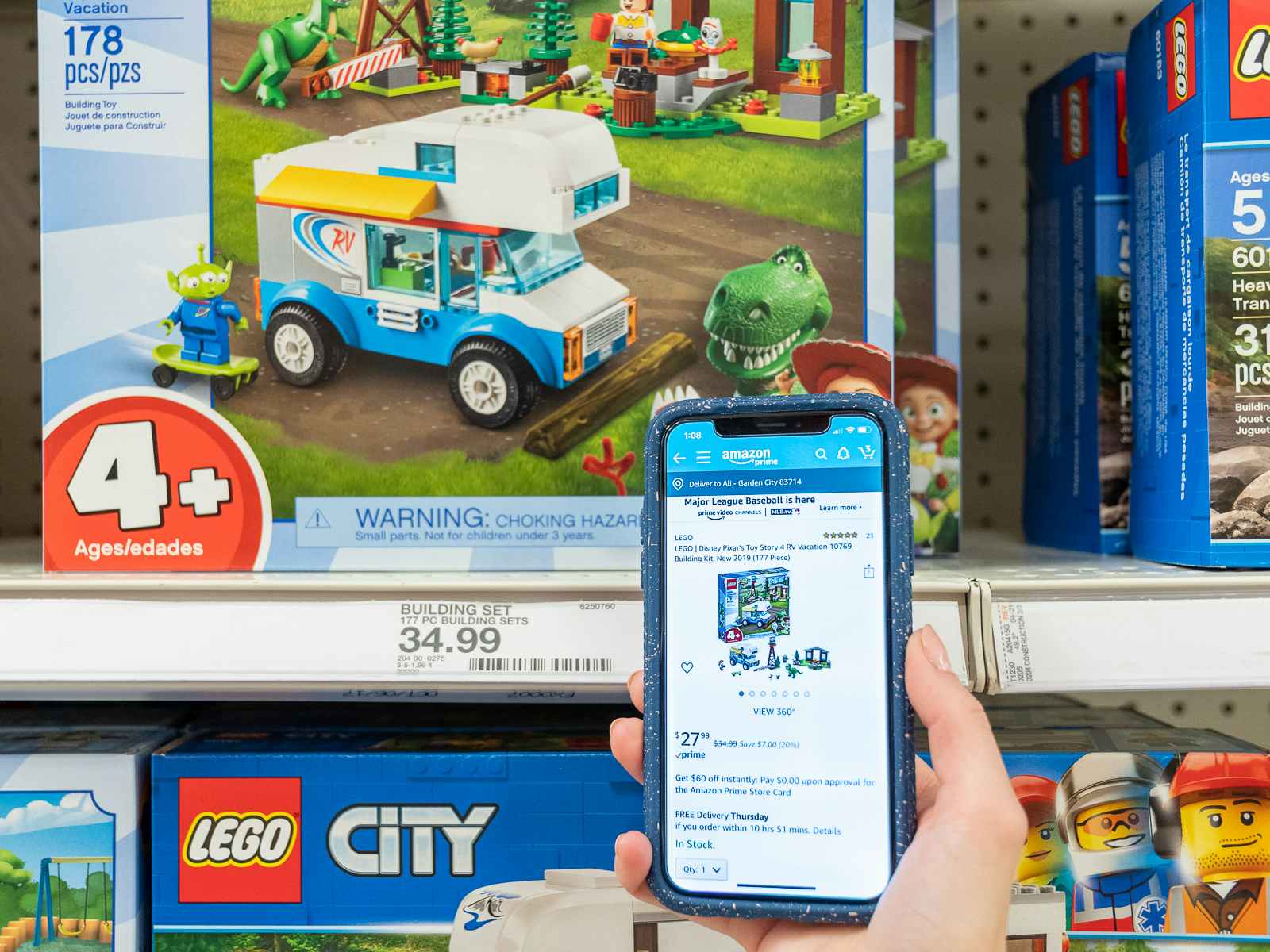 A hand holding a phone showing an Amazon listing for a toy in front of the same toy on the shelf at Target