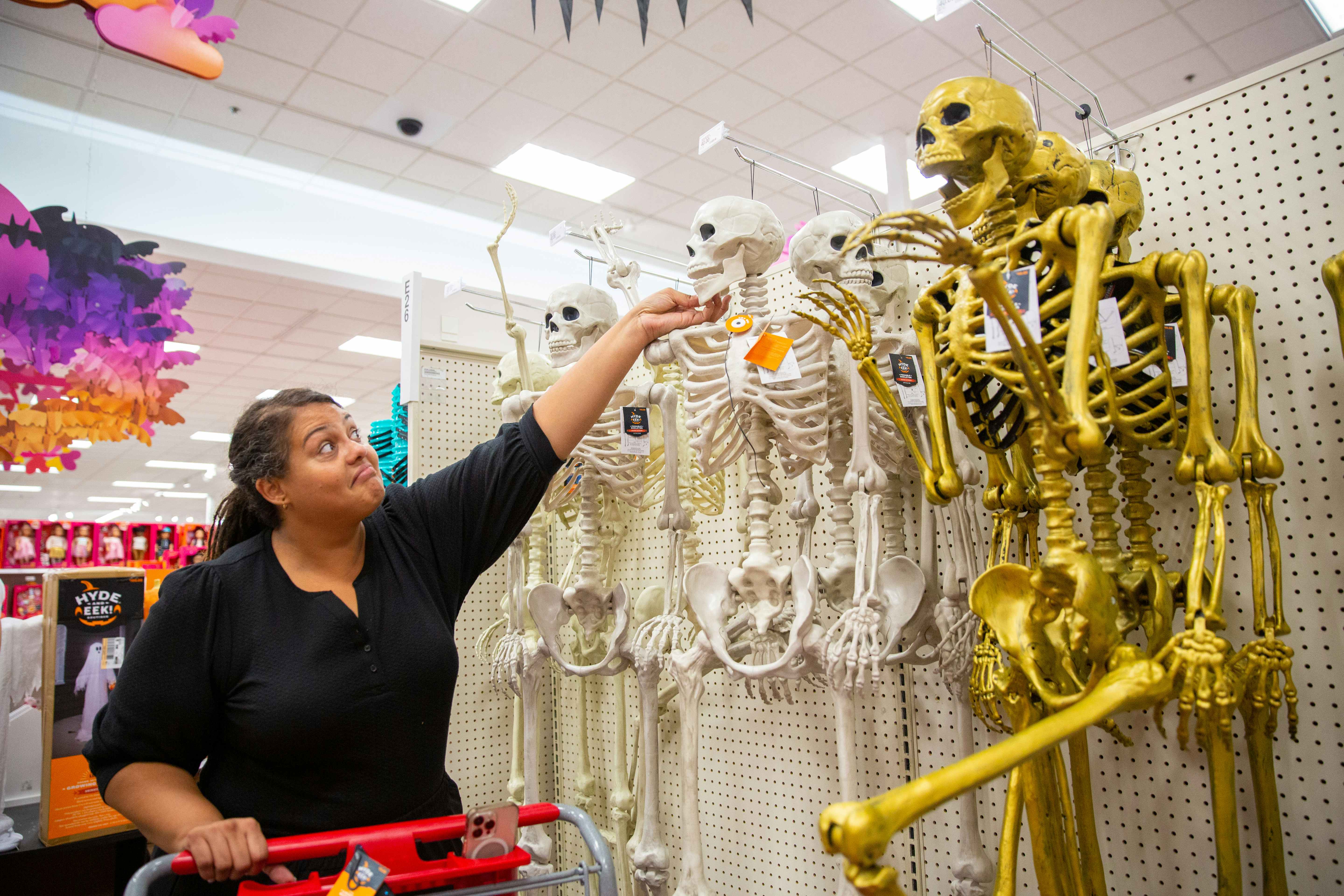 Person grimaces while touching a skeleton,