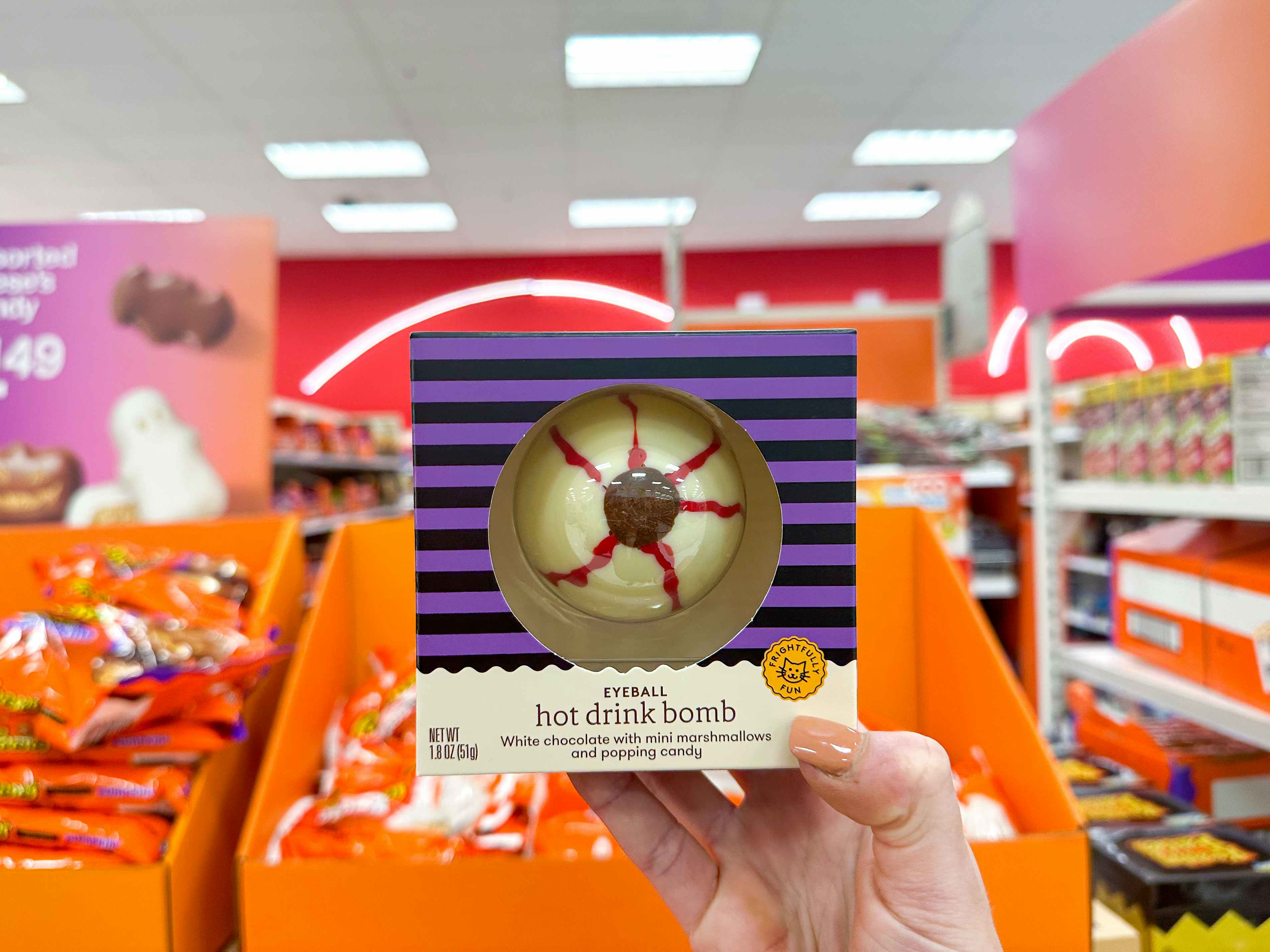 a person's hand holding up a halloween eyeball hot drink bomb at Target