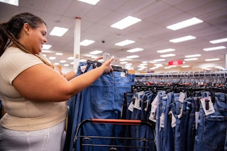 Person picking up a stack of jeans of jeans from a