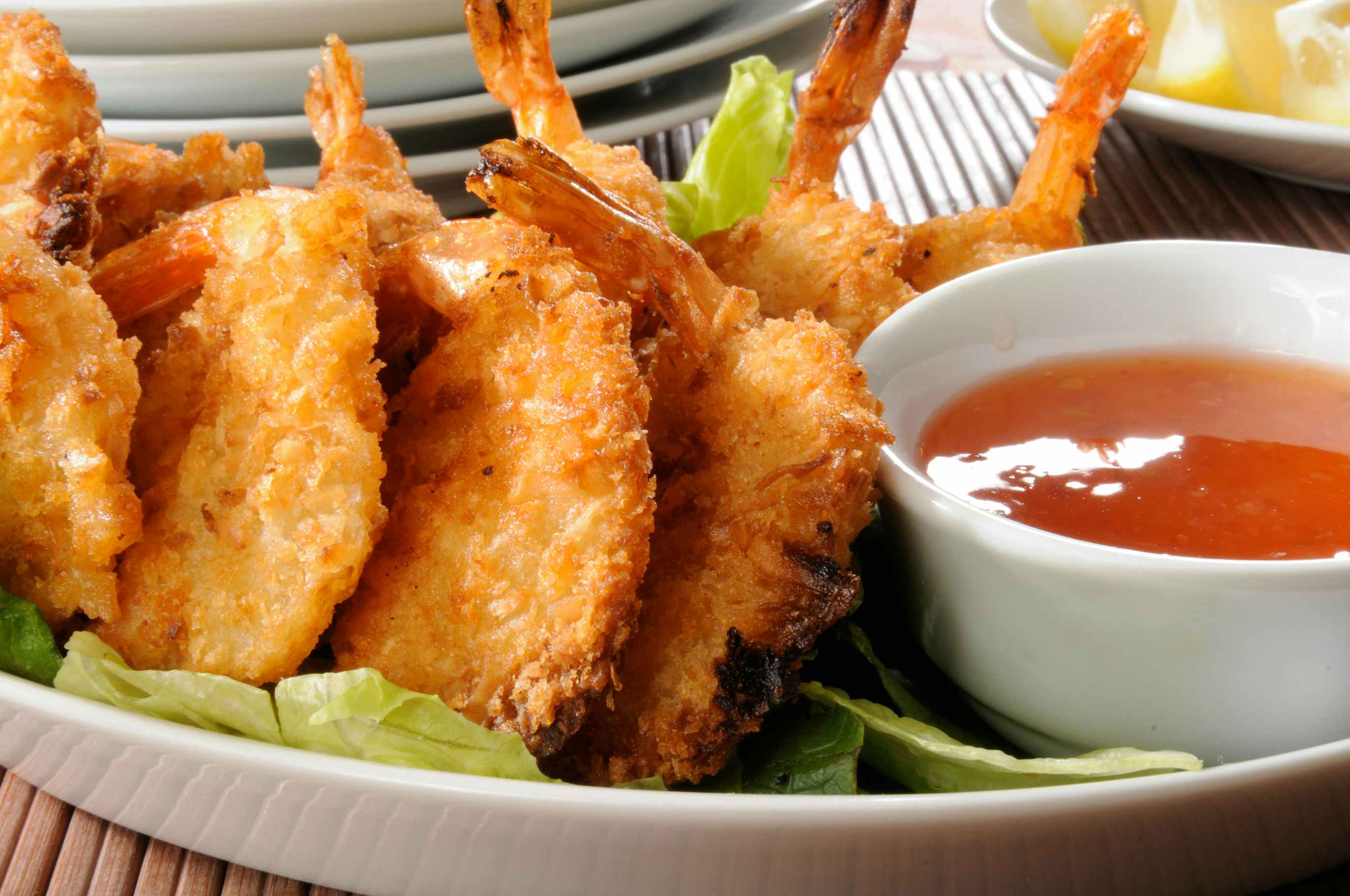 Coconut Shrimp plated next to a bowl of dipping sauce