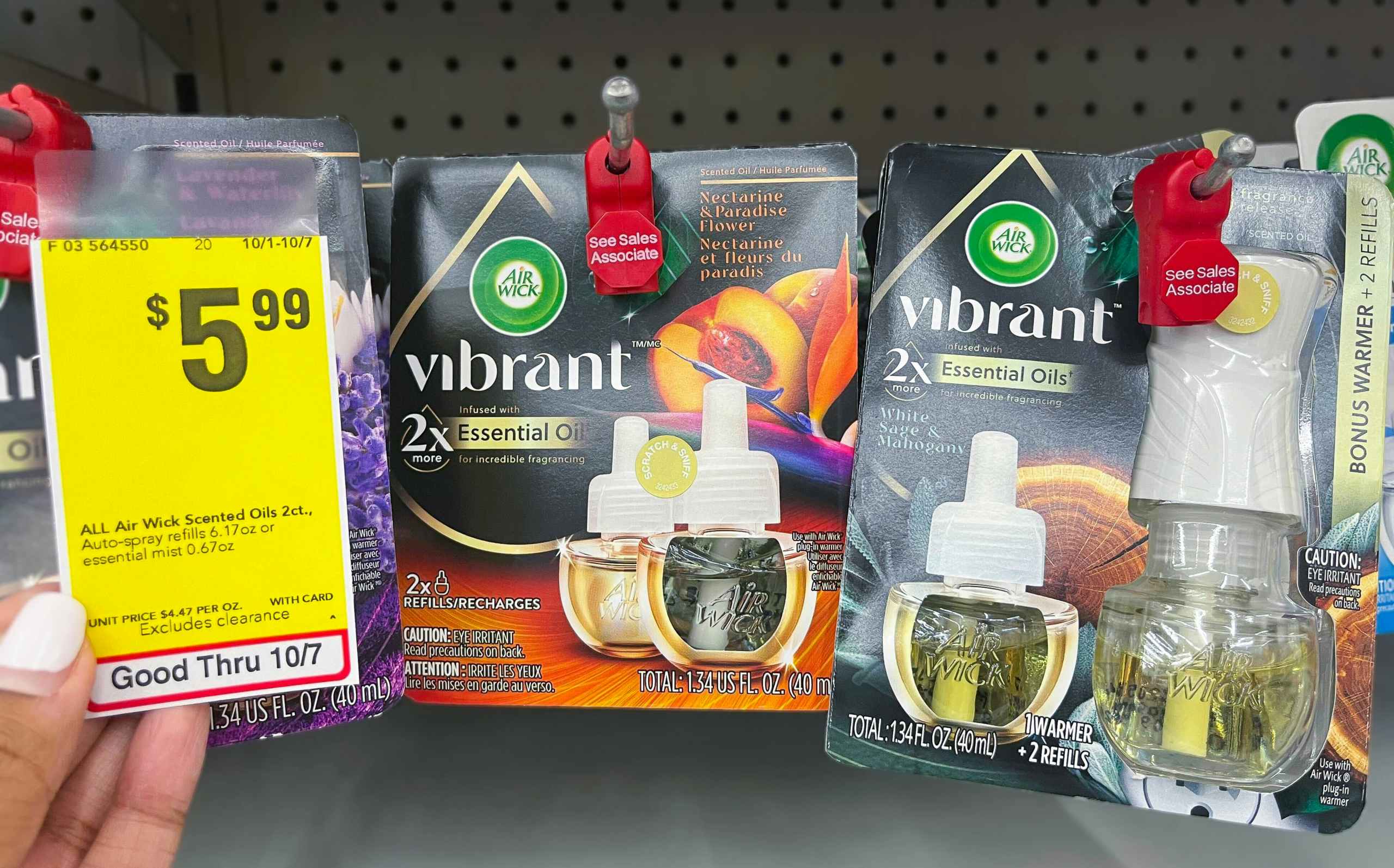 hand holding sales tag next to air wick oil refills