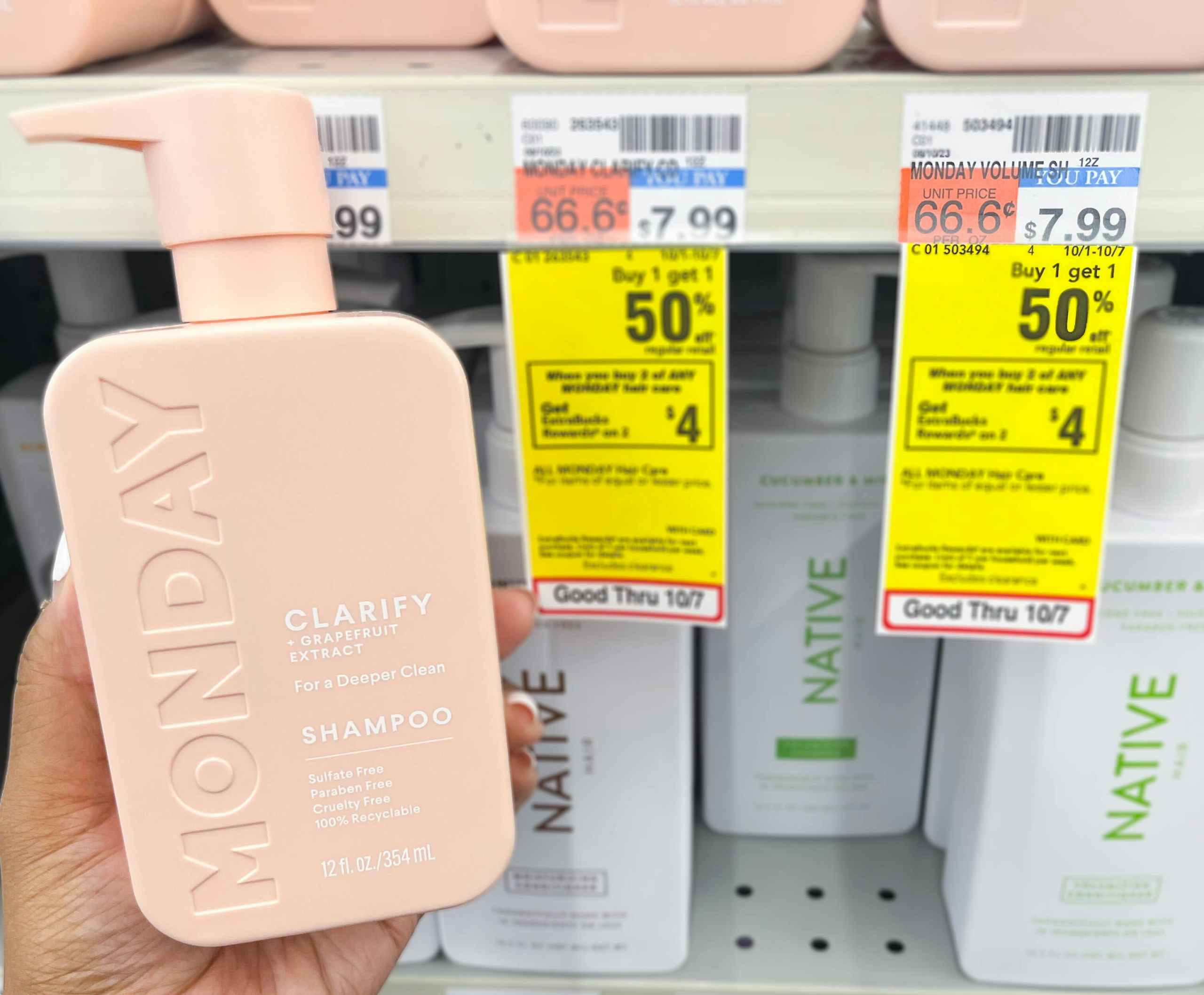 person holding a bottle of Monday shampoo next to sales tag