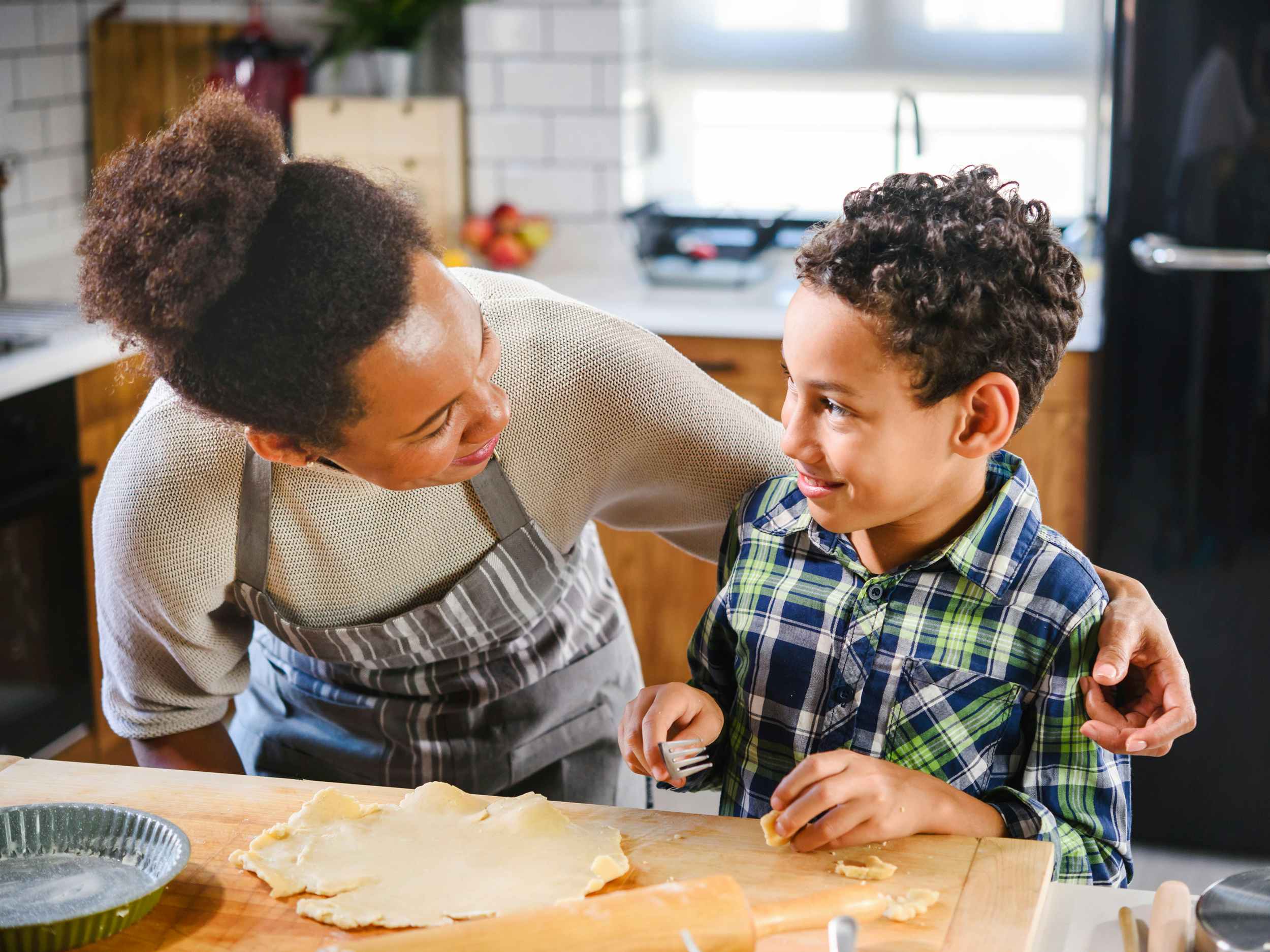 mother and child having fun baking a pie in the kitchen