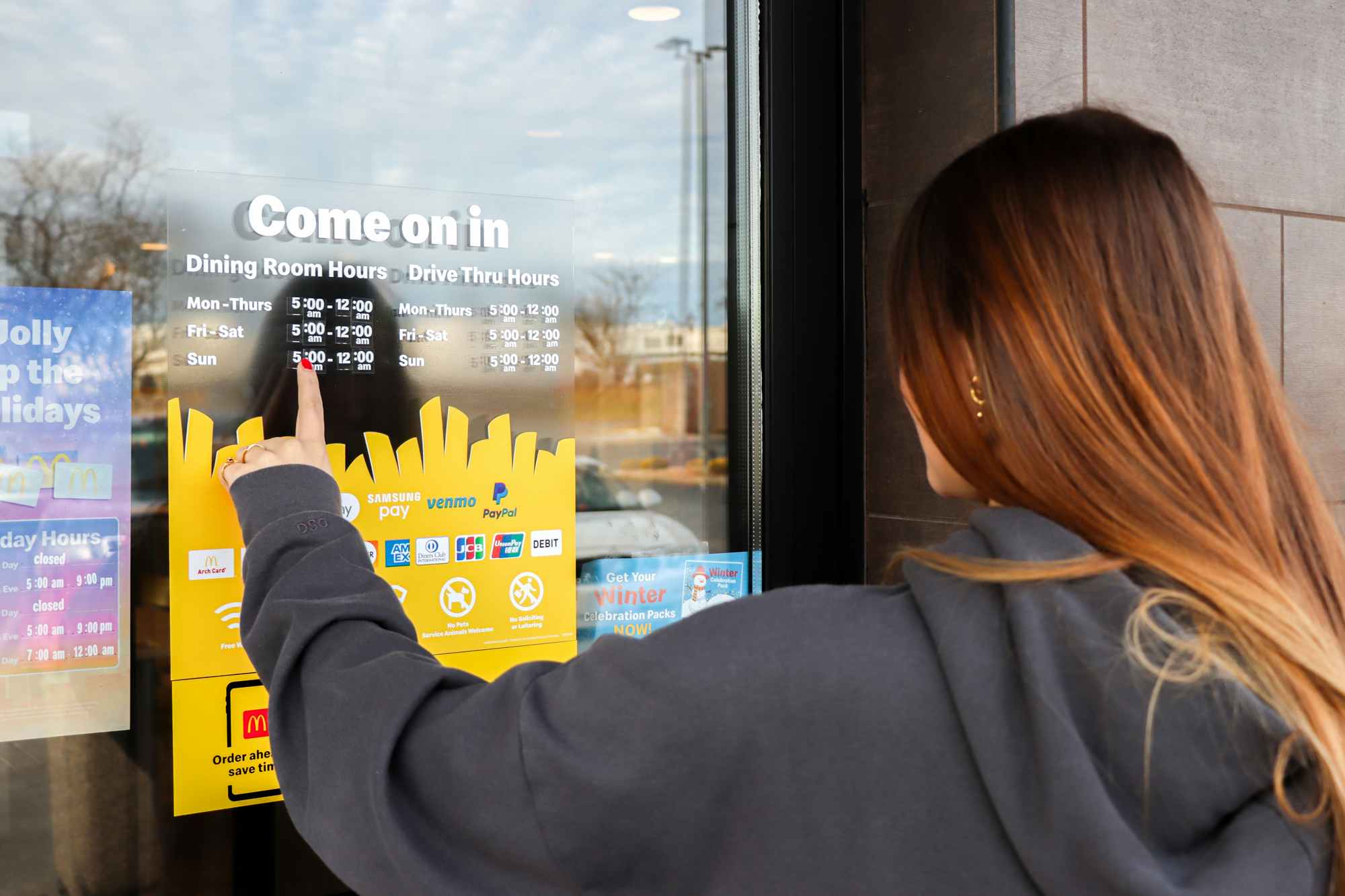 a person pointing to mcdonalds store hours
