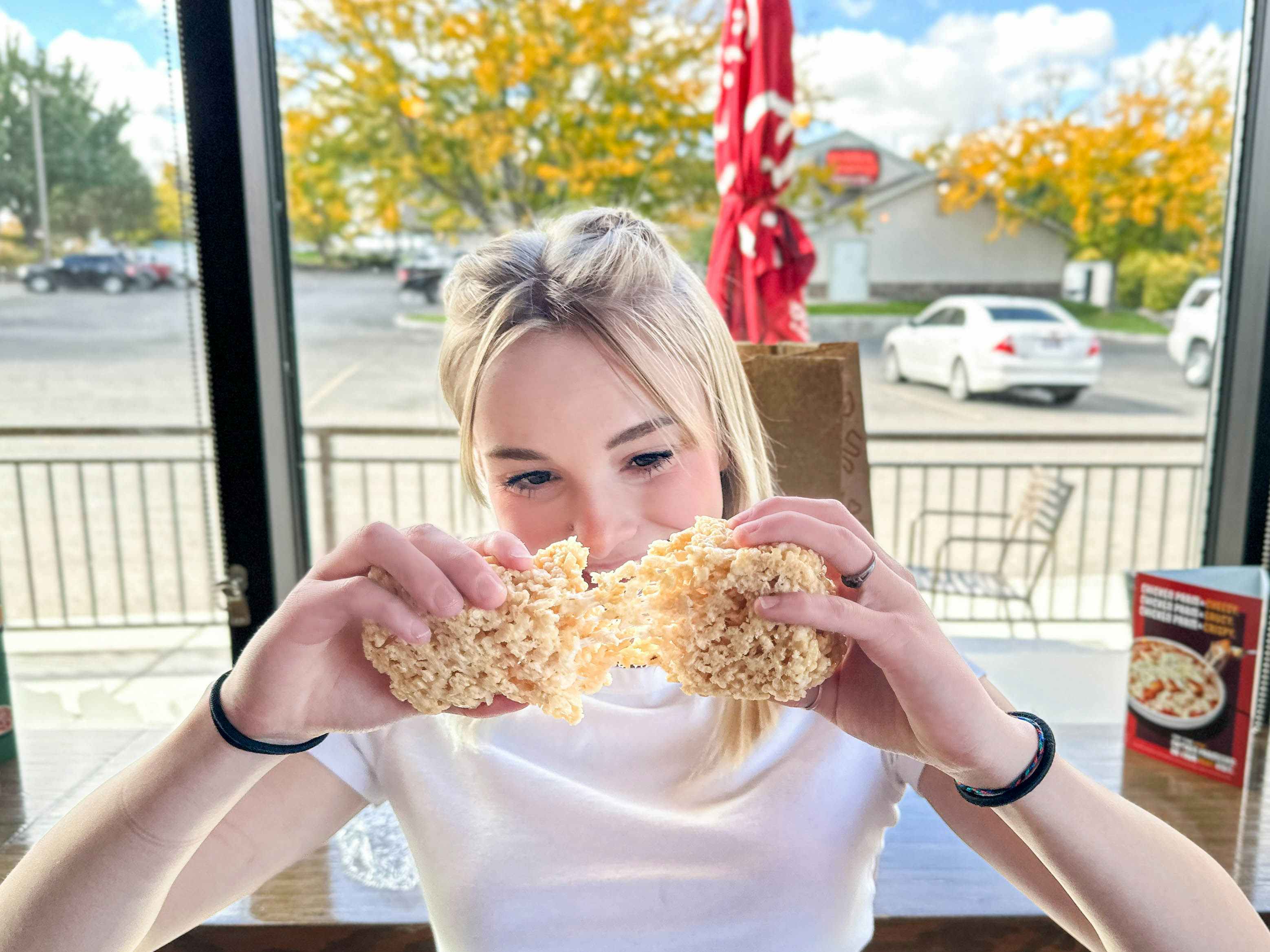 a person looking at and pulling apart a rice crispy treat in Noodles and Company