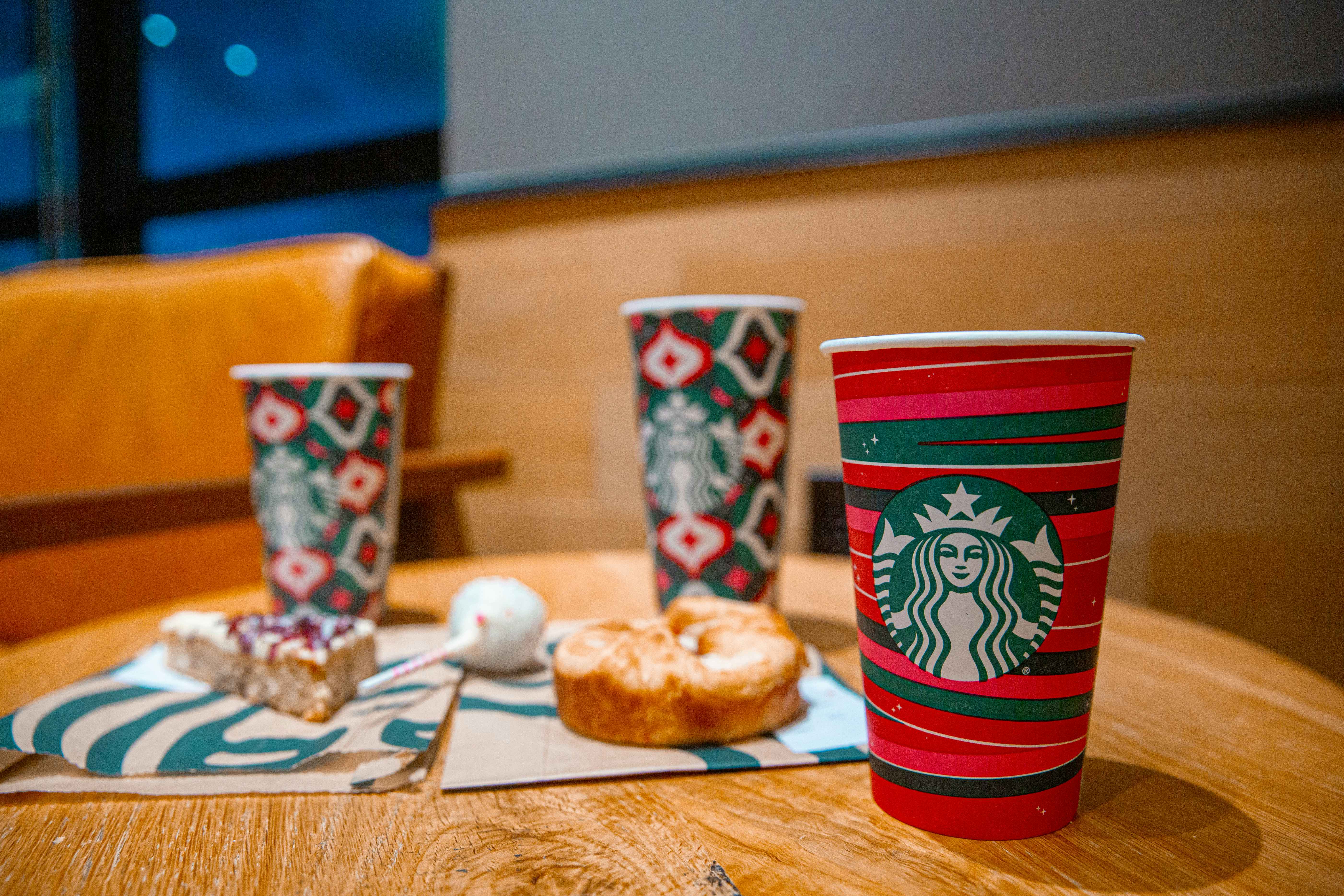 Three starbucks cups with the cranberry bliss bar and a sugar plum danish