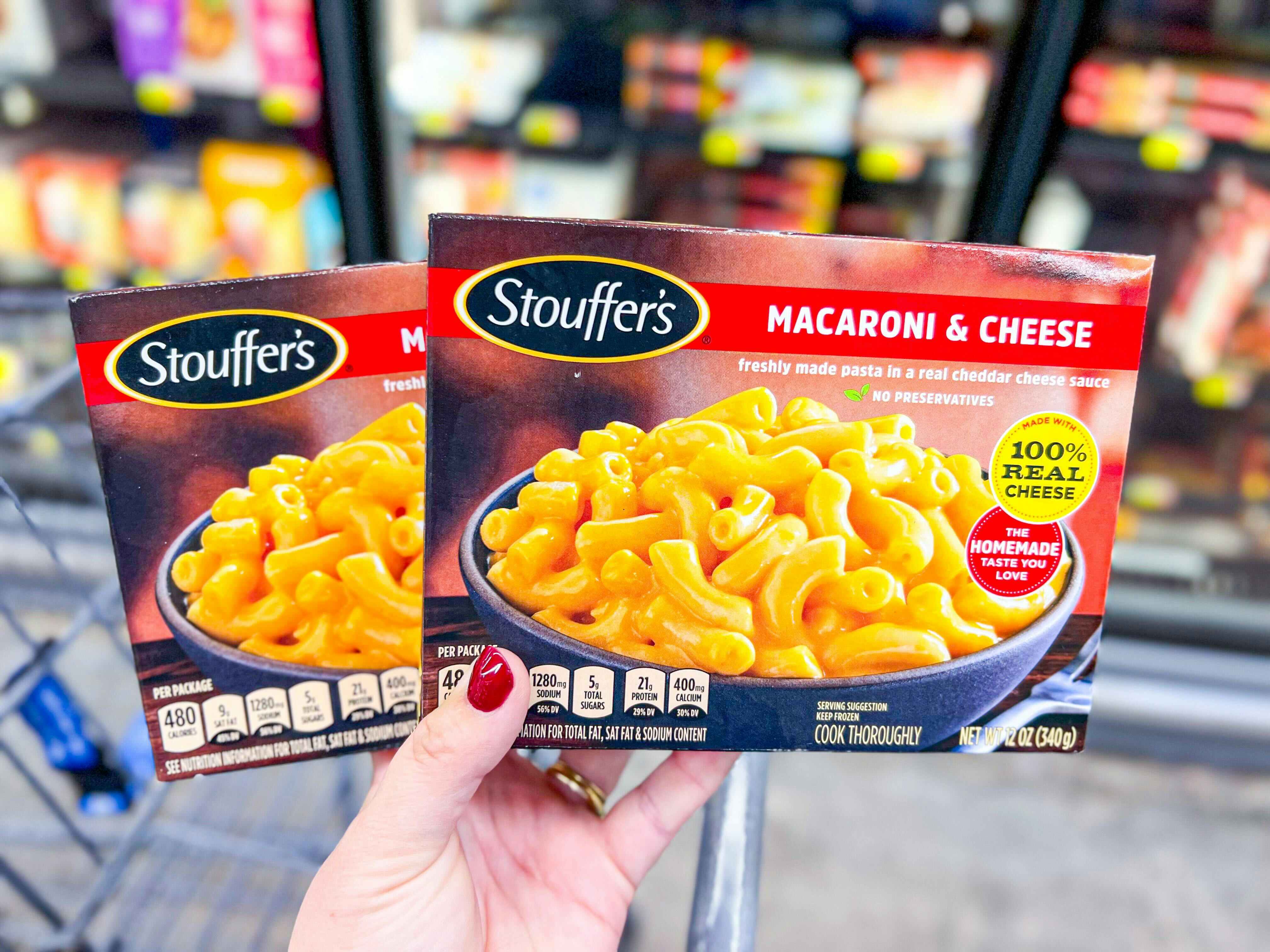 Hand holding two boxes of Stouffer's Mac & Cheese