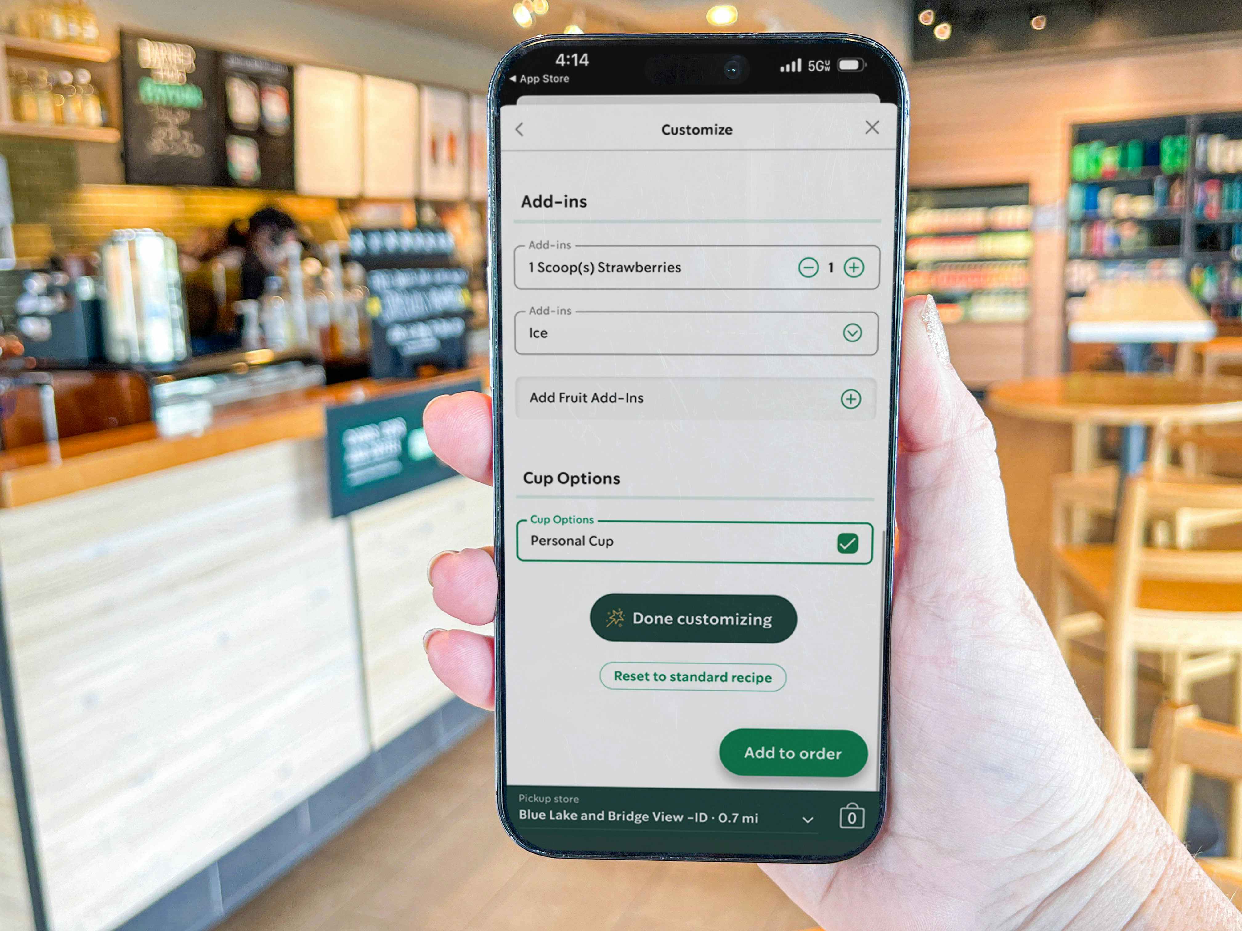 a phone being held outside starbucks with the mobile app on screen
