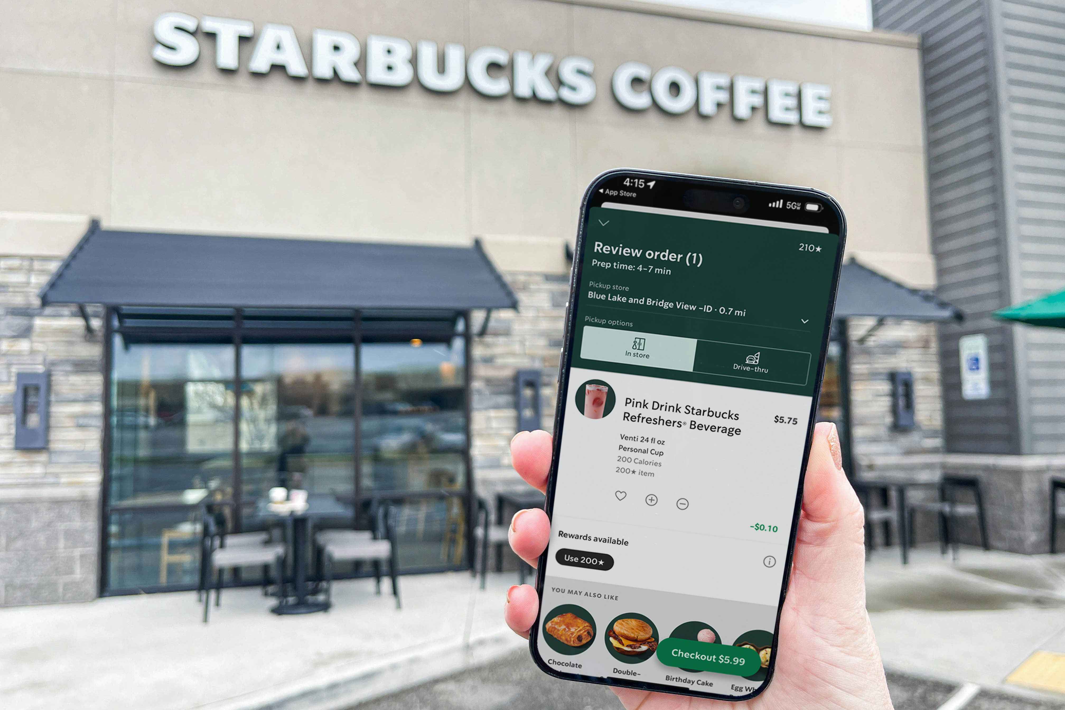 a phone being held outside starbucks with the mobile app on screen